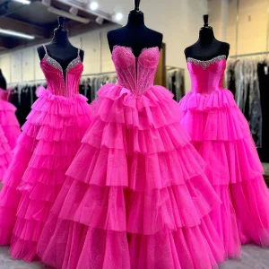 Robe de bal longue en tulle fuchsia à volants et décolleté en cœur